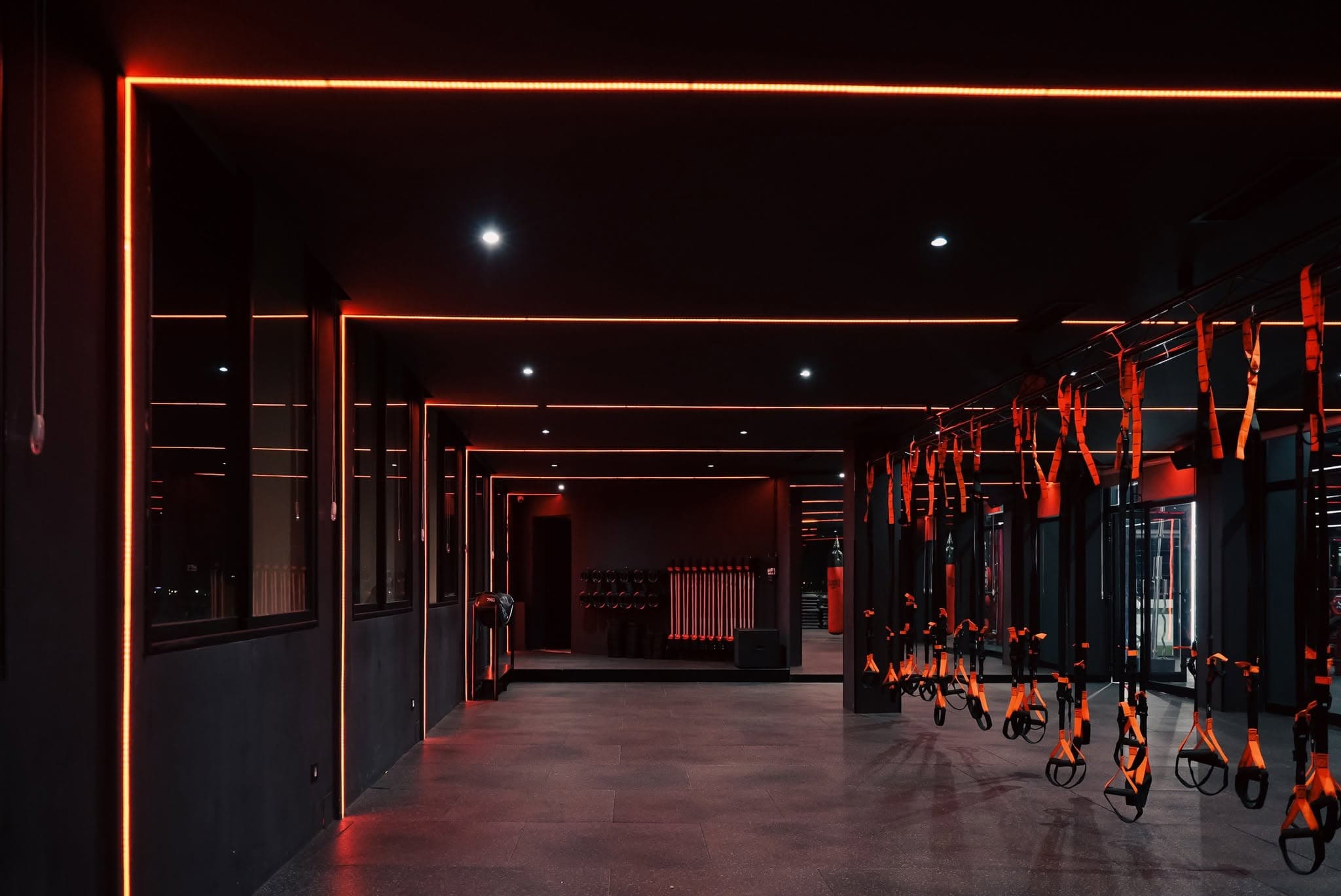 Sangles de suspension alignées sous les LED rouges de l'espace cours